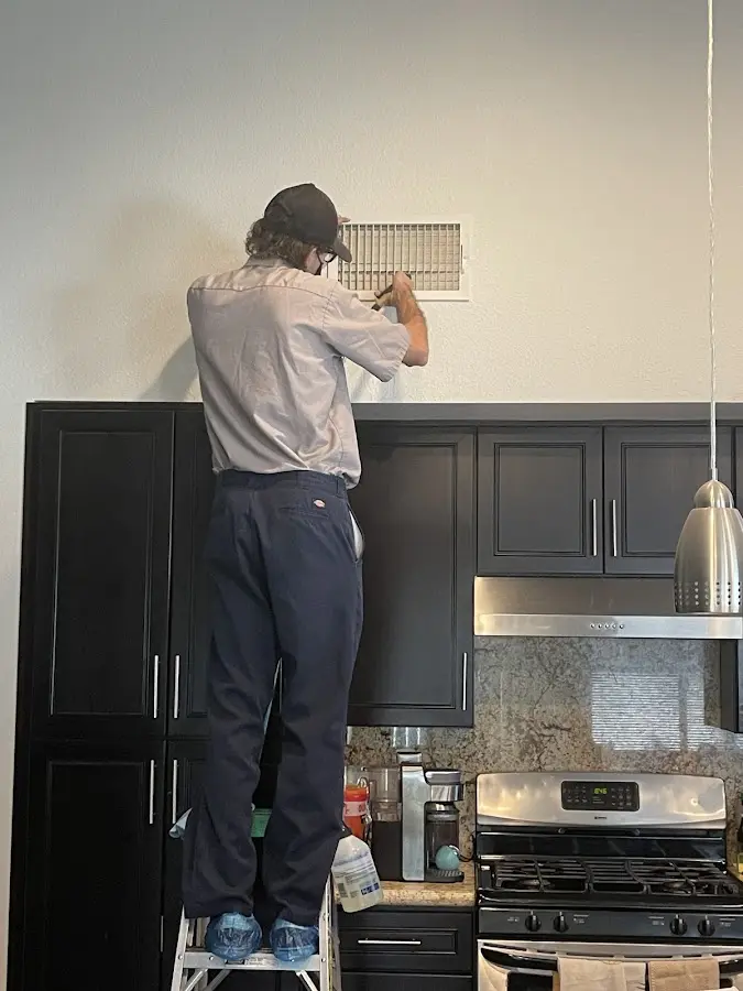 Technician inspecting an air vent during HVAC service in Abilene